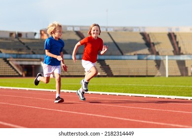 Child Running In Stadium. Kids Run On Outdoor Track. Healthy Sport Activity For Children. Little Girl And Boy At Athletics Competition Race. Young Athlete Training. Runner Exercising. Jogging For Kid.