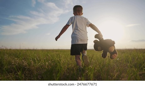 A child is running with a teddy bear. Kid people happy concept. Silhouette of a child running in the park. Silhouette of a child running around in the park with a teddy lifestyle bear. - Powered by Shutterstock