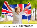 Child running with UK flag. British supporter. Little Britain fan kid celebrating victory. Children watching UK national team play. Championship game. Go Britain!