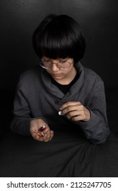 Child Sad With Pills In His Hand. Medicine For Depression, Fever, Stomach Pain.