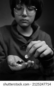 Child Sad With Pills In His Hand. Medicine For Depression, Fever, Stomach Pain. Black And White.