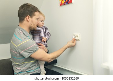 Child Safety At Home. Father Takes Care To Protect Kid From Electrical Injury