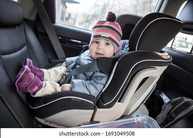 Child Safety Seat With Smiling Infant Child Is On Back Seat Of Car, A Kid Eight Month Old