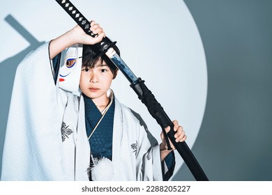 Child samurai wearing kimono. Japanese costume play.