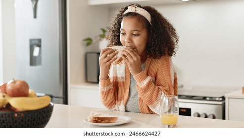 Child, sandwich and eating lunch in home kitchen or healthy nutrition with orange juice, student or breakfast. Girl, kid and morning hungry or bread snack in apartment for fiber meal, diet or food - Powered by Shutterstock