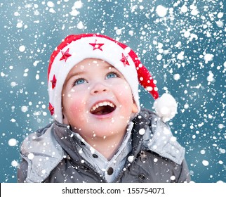 Child With Santa Claus Christmas Hat Looking At Snow Falling