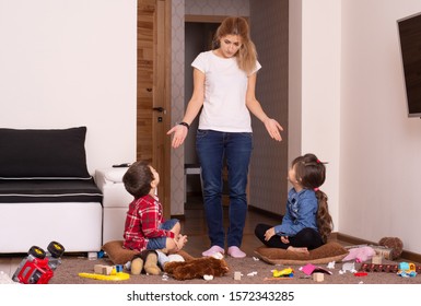 Child Scattered Toys. Mess In The House. Kids Play And Do Not Obey Mother. Siblings