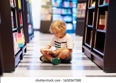 Child in school library. Kids read books. Little boy reading and studying. Children at book store. Smart intelligent preschool kid choosing books to borrow.