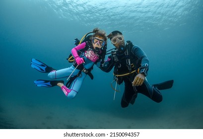 Child Scuba Diver And Adult Diver Go Diving