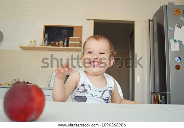 child is seated at the table, the\
selective focus of the portrait, the emotional\
baby