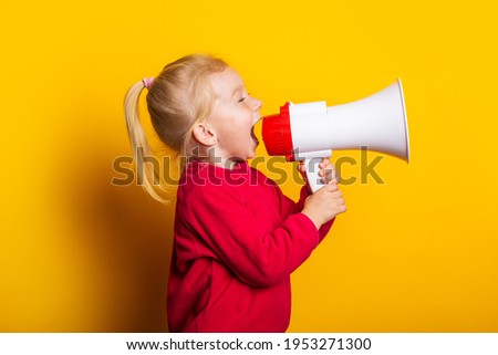 child shouts into a white megaphone on a bright yellow background.