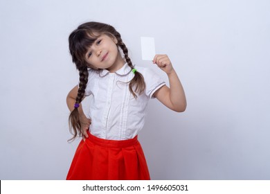 Child Showing Empty Blank Paper, Copy Space. Kid Holding Credit Card In Hands. Realistic White Mockup Of A Bank Or Gift Card. Ready To Used In Your Showcase.