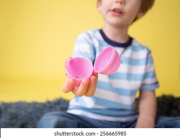 Child Showing An Open Plastic Easter Egg, Easter Egg Hunt Concept.