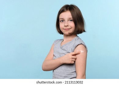 Child Shows Band Aid After Vaccination. Preteen Girl After Getting Vaccine. Vaccination And Protection Against Covid 19. Population Antiviral Immunization. Children Covid-19 Prevention. Health Care