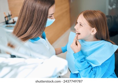 Child shows his teeth to the dentist with a hygienist - Powered by Shutterstock