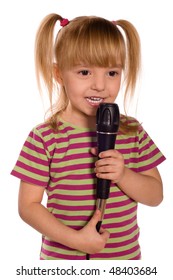 Child singing with a microphone. Funny little girl isolated on white background. Beautiful caucasian model.
