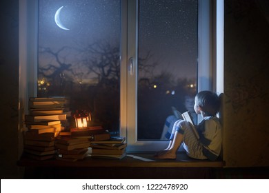 
The child sits on the windowsill at night looking at the stars and dreams. - Powered by Shutterstock