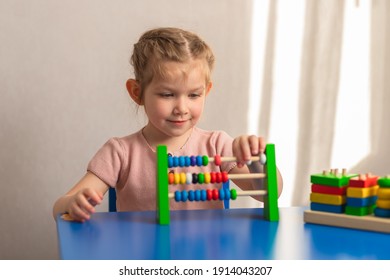 
The child sits at the table, counts on the abacus and smiles.Children's wooden toy. Educational logic toys for children. Montessori games for child development. - Powered by Shutterstock