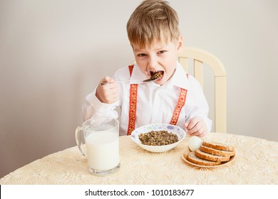 The Child Sits At The Table And Eats The Lentils, Healthy Eating, Milk, Eggs, Bread