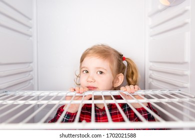 Child Sitting In An Empty Refrigerator, Close-up