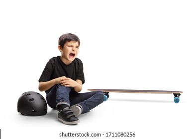 Child Sitting On The Floor Crying And Holding Knee Hurt From A Skateboard Isolated On White Background