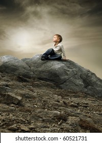 Child Sitting On A Rock