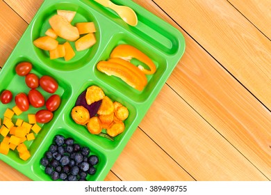 Child Size Lunch Tray With Cherry Tomatoes, Melon, Blueberries And Sweet Pepper Fruit On Wooden Table