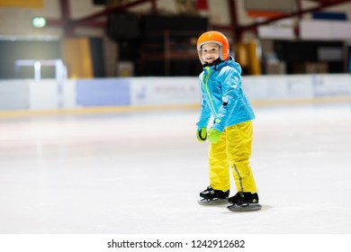 Child Skating On Indoor Ice Rink. Kids Skate. Active Family Sport During Winter Vacation And Cold Season. Little Boy In Colorful Wear Training Or Learning Ice Skating. School Sport Clubs