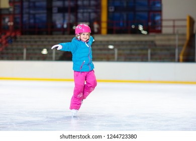 Child Skating On Indoor Ice Rink. Kids Skate. Active Family Sport During Winter Vacation And Cold Season. Little Girl In Colorful Wear Training Or Learning Ice Skating. School Sport Activity And Clubs