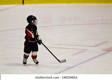 Child Skating And Playing Hockey In An Arena