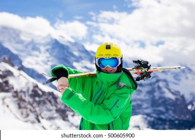 Child Skiing In Mountains. Active Teenager Kid With Safety Helmet, Goggles And Poles. Ski Race For Young Children. Winter Sport For Family. Kids Ski Lesson In Alpine School. Young Skier Racing In Snow