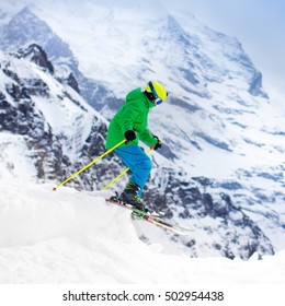 Child Skiing In Mountains. Active Teenager Kid With Safety Helmet, Goggles And Poles. Ski Race For Young Children. Winter Sport For Family. Kids Ski Lesson In Alpine School. Young Skier Racing In Snow