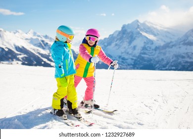 Child Skiing In The Mountains. Kid In Ski School. Winter Sport For Kids. Family Christmas Vacation In The Alps. Children Learn Downhill Skiing. Alpine Ski Lesson For Boy And Girl. Outdoor Snow Fun.