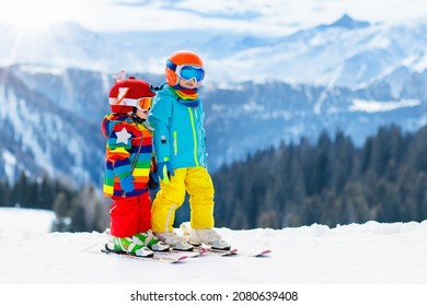 Child Skiing In The Mountains. Kid In Ski School. Winter Sport For Kids. Family Christmas Vacation In The Alps. Children Learn Downhill Skiing. Alpine Ski Lesson For Boy And Girl. Outdoor Snow Fun.