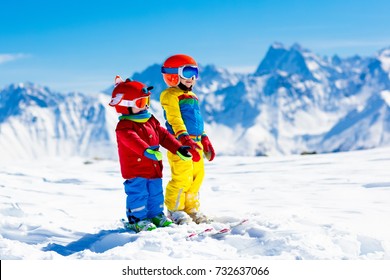 Child Skiing In The Mountains. Kid In Ski School. Winter Sport For Kids. Family Christmas Vacation In The Alps. Children Learn Downhill Skiing. Alpine Ski Lesson For Boy And Girl. Outdoor Snow Fun.