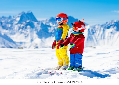 Child Skiing In The Mountains. Kid In Ski School. Winter Sport For Kids. Family Christmas Vacation In The Alps. Children Learn Downhill Skiing. Alpine Ski Lesson For Boy And Girl. Outdoor Snow Fun.