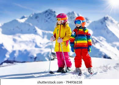 Child Skiing In The Mountains. Kid In Ski School. Winter Sport For Kids. Family Christmas Vacation In The Alps. Children Learn Downhill Skiing. Alpine Ski Lesson For Boy And Girl. Outdoor Snow Fun.