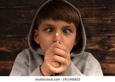 A child with slanting eyes looks at a burning lighter.