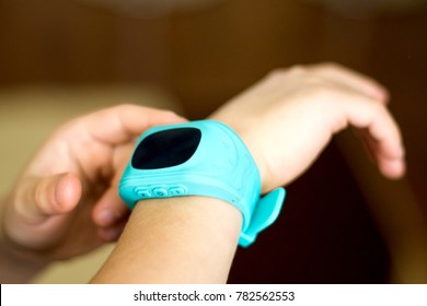 Child Smart Watch Connected To A Smartphone With GPS Tracker And Mobile Phone Function On Kid's Hands With On/Off Button And Emergency Call Buttons