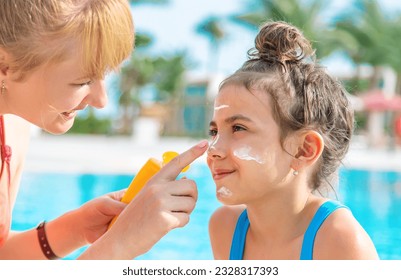 The child is smearing sunscreen on the mother. Selective focus. Nature. - Powered by Shutterstock