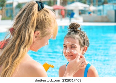 The child is smearing sunscreen on the mother. Selective focus. Nature. - Powered by Shutterstock