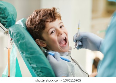 Child smiling while sitting in the dentist's chair.