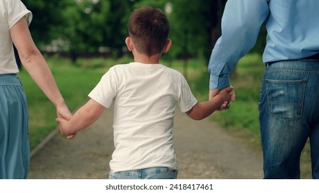 Child son walks with mom dad in park holding hands. Child, Mother, father, family runs. Happy family with baby boy walking outdoor, summer. Parents child run together, family weekend. Boy kid dad mom - Powered by Shutterstock