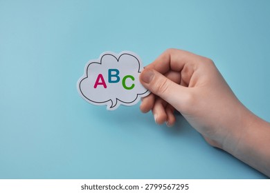 Child speech development concept with speech bubble and alphabet letters in kid hand