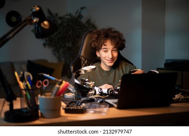 Child Spends Time At Desk In Room Watching Instructional Videos On Laptop, Imitates Video Makers And Solders Robot By Self, Connects Wires, Creates Toy Electrical System