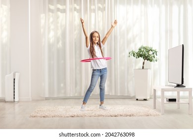 Child Spinning A Hula Hoop At Home In A Living Room