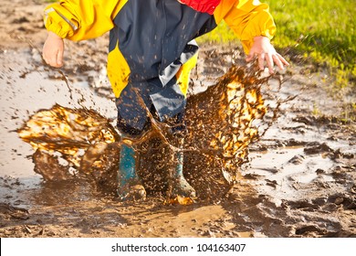 Child Splashing In Muddy Puddle, Having Fun