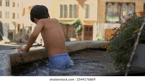 Child splashing through shallow water in an old stone fountain with big splash, enjoying summer fun, captured in super slow motion at 800 fps in a lively town square - Powered by Shutterstock