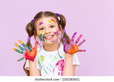 A child stained in multicolored paints will have to be creative. The concept of children's creativity on a pink isolated background. - Shutterstock ID 2202383651