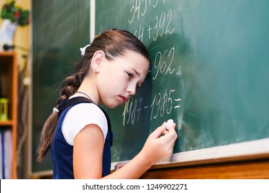 Child Standing Near The Blackboard In School With A Sad Face. Adolescent Learning Difficulties